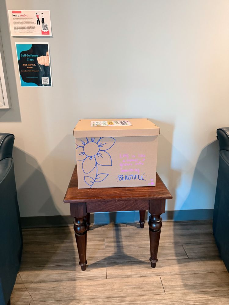A hand-decorated donation box reading Life is like a flower, it grows into something beautiful